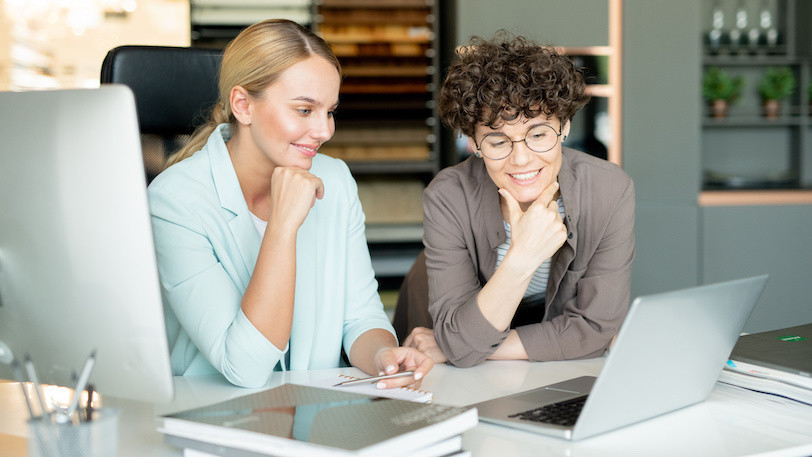 two women watching something on computer