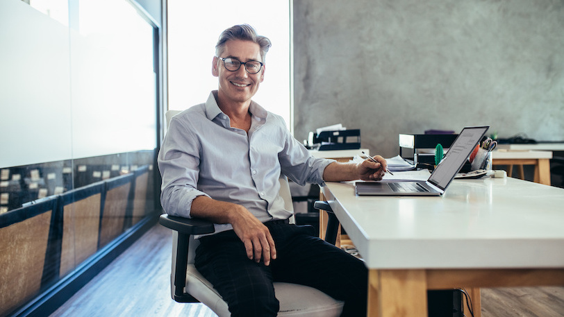 Business man sitting at desk and smiling